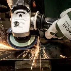Rękawica Hitachi z tarczą szlifierską generuje iskry, pokazując siłę tarcia statycznego podczas pracy z metalem.