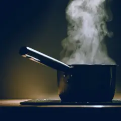 Para unos fideos perfectos, el parowanie jest kluczowe. Garnek z parującą wodą na ciemnym tle.
