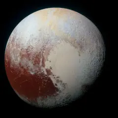 Pluton planeta w kosmosie, z widocznymi czerwonymi i białymi obszarami, przypominającymi serce.