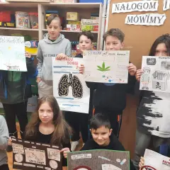 Dzieci trzymają plakaty o szkodliwości używek, m.in. o marihuanie i papierosach.