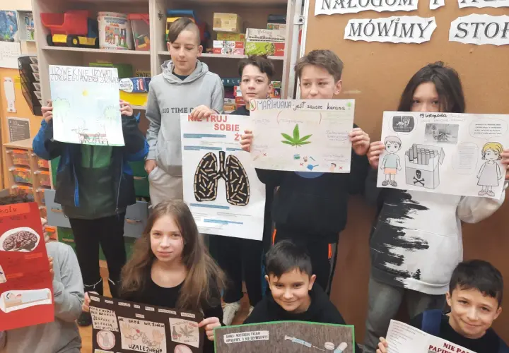 Dzieci trzymają plakaty o szkodliwości używek, m.in. o marihuanie i papierosach.