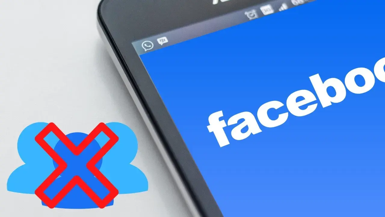 Chcesz wiedzieć, jak usunąć grupę na FB? Ikona z przekreślonymi ludzikami obok ekranu telefonu z logo Facebooka sugeruje rozwiązanie.