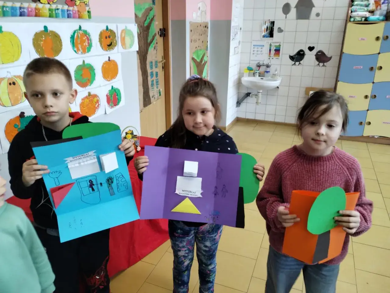 Dzieci prezentują swoje prace plastyczne, pokazując, co to jest edukacja: tworzenie, rozwijanie wyobraźni i wspólne uczenie się.